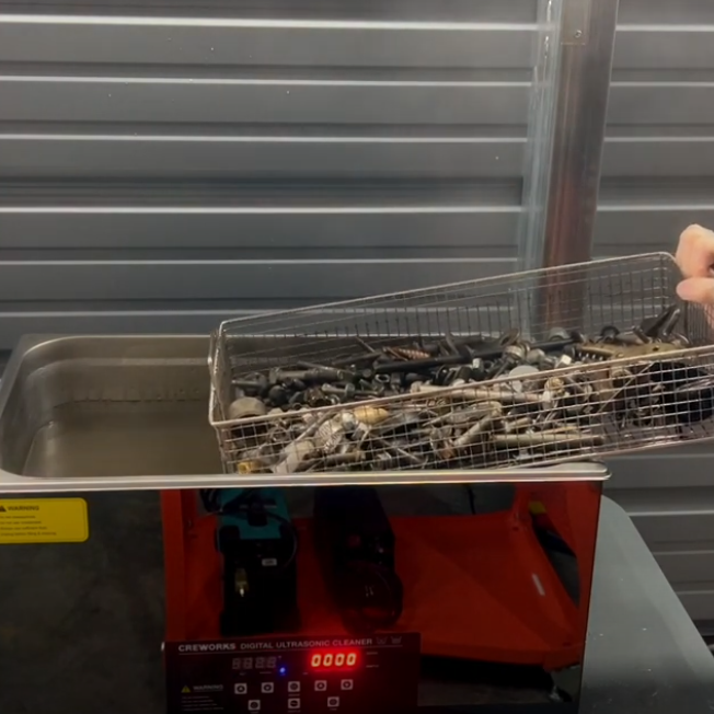 ultrasonic cleaner with a basket of auto parts